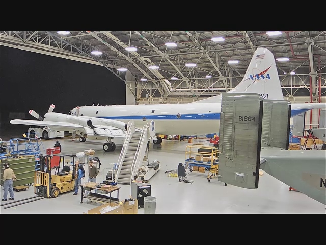 a white and blue plane some people people and other equipment