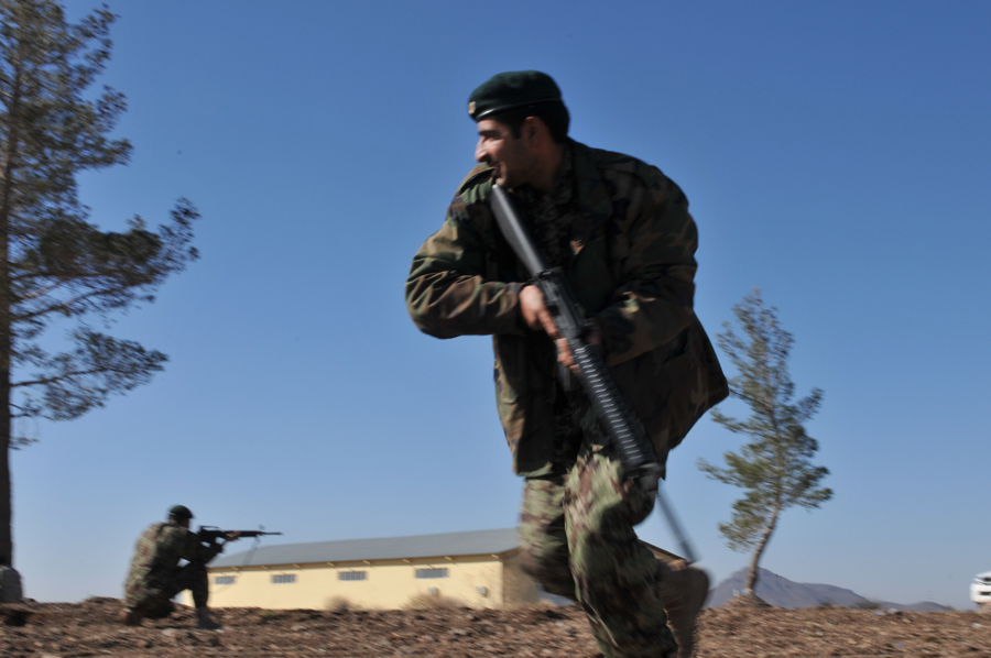 a man with a gun running on the ground