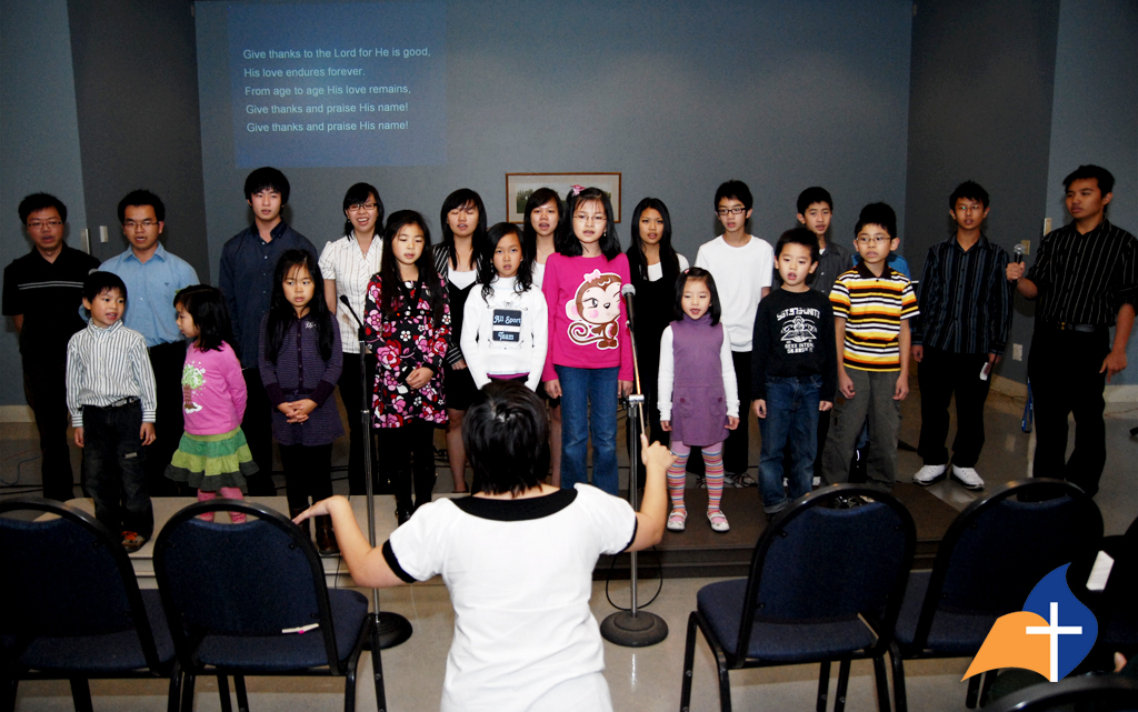 a group of children are standing near a television