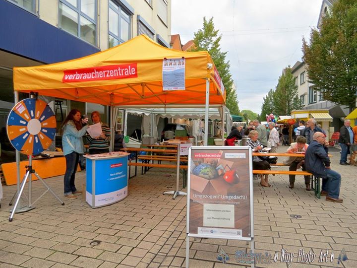 a market tent with people sitting and talking under it