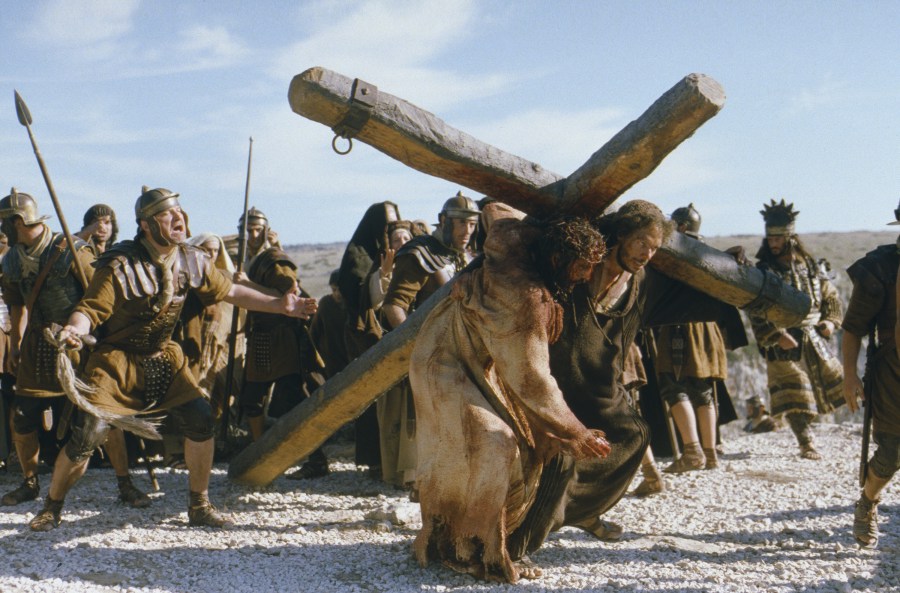 a group of people carrying two large wooden crosses in front of them