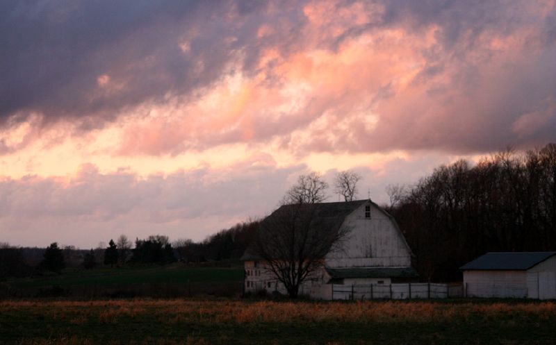 a barn sits under dark and cloudy skies