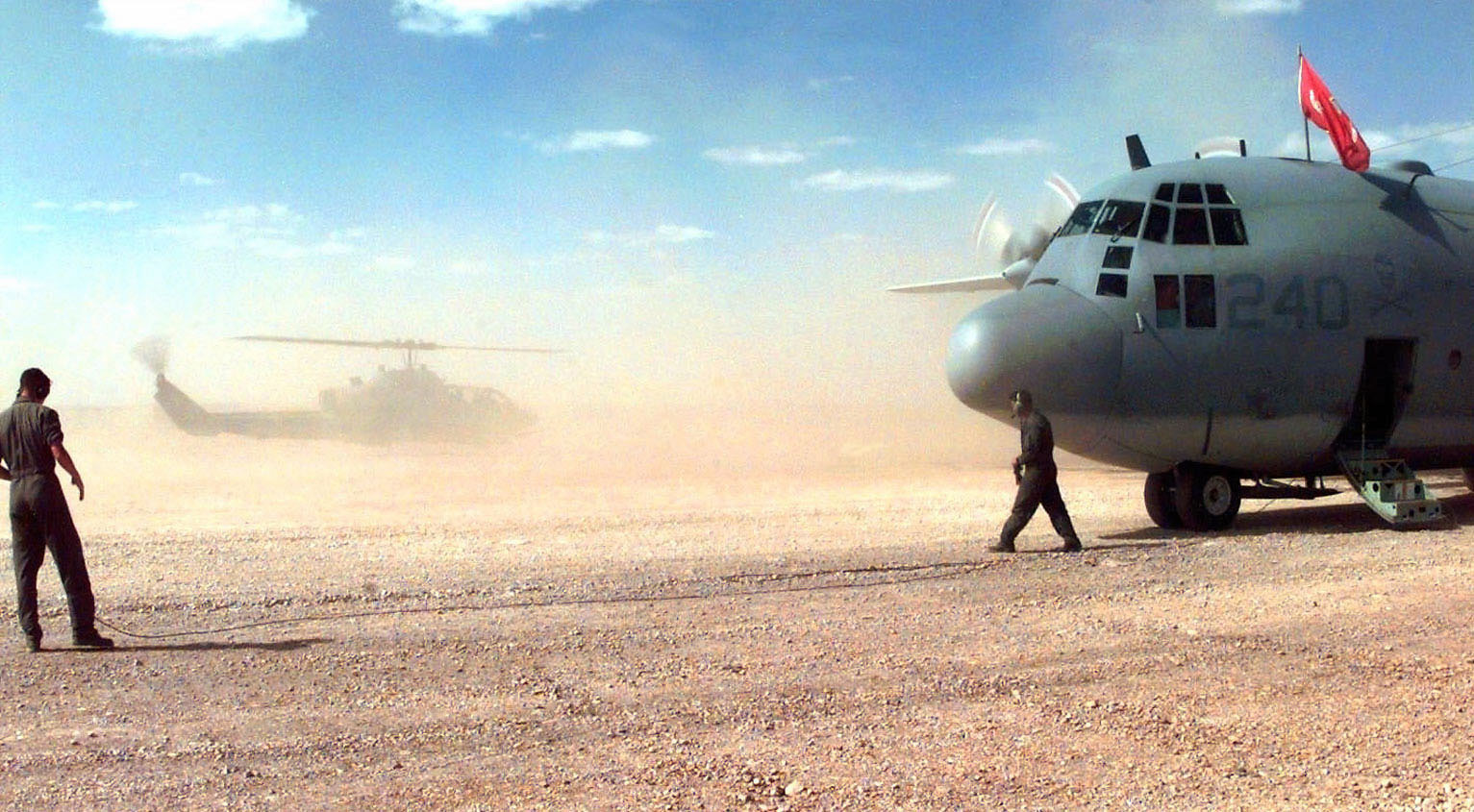 a plane on a desert plain next to some men