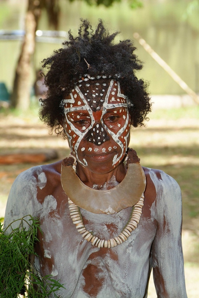 a woman with a painted face holds up plants