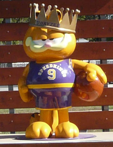 a close up of a toy mascot near a bench