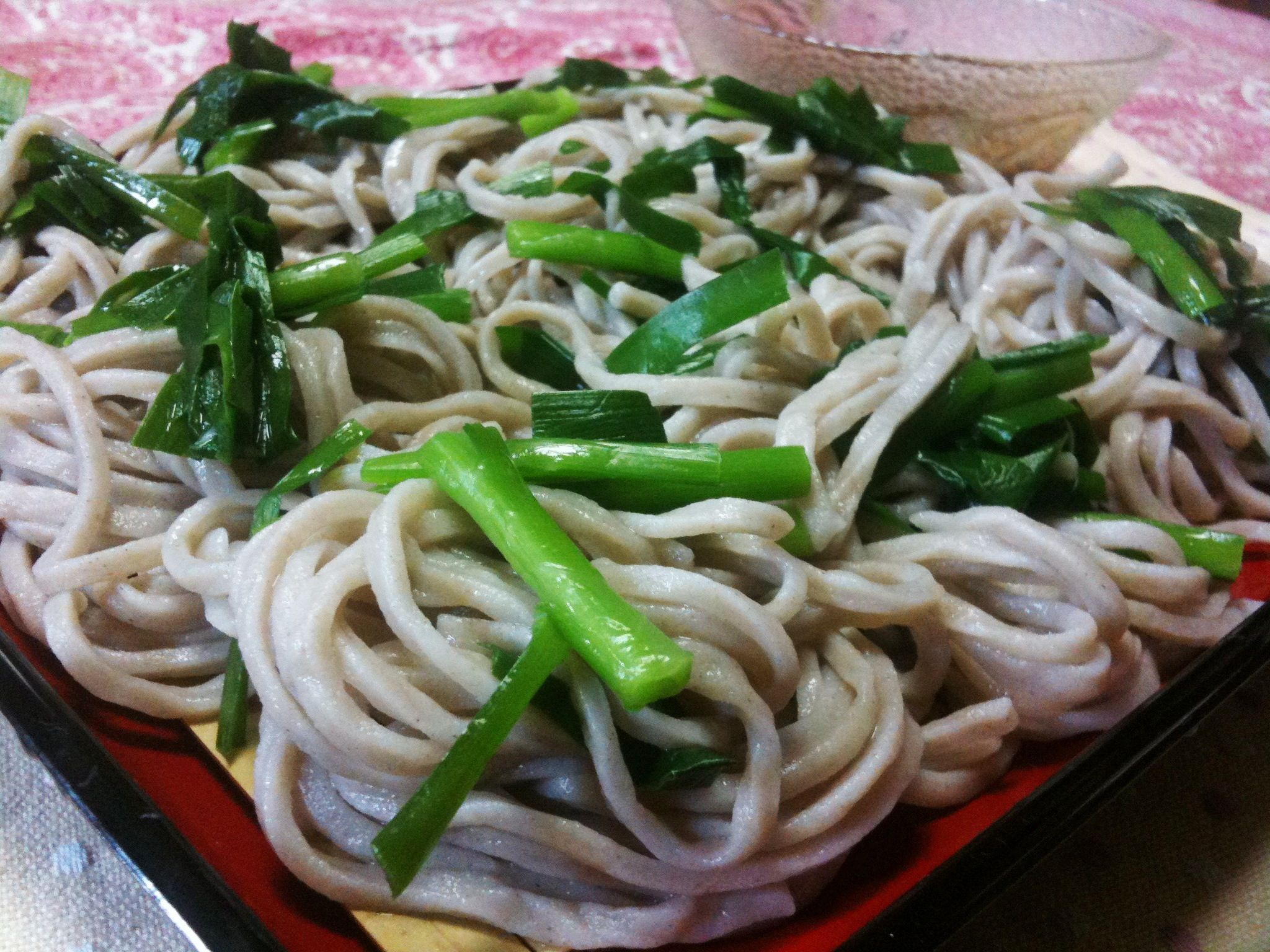 a dish full of noodles and green vegetables