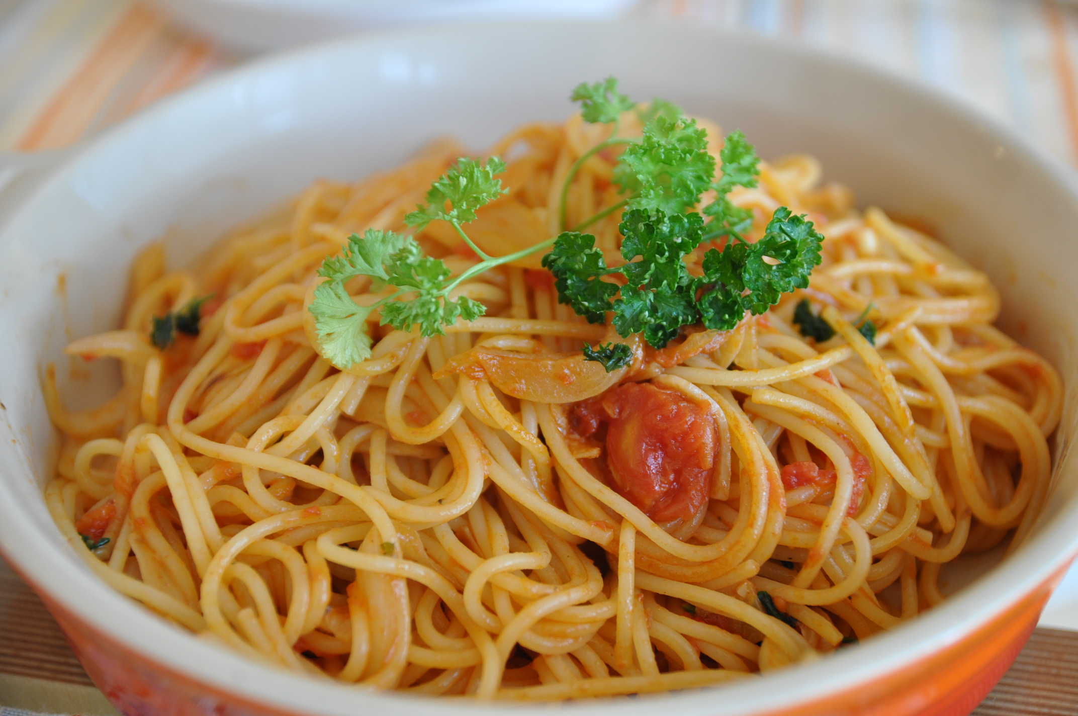 a white bowl filled with lots of pasta and parsley