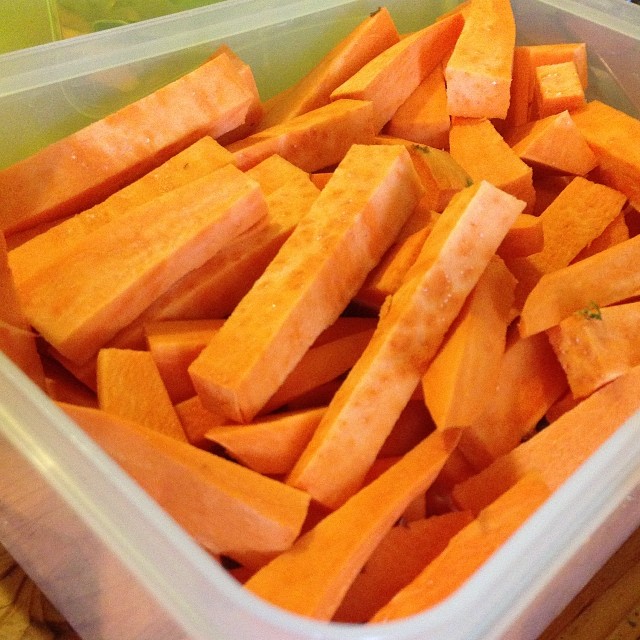 large plastic containers filled with sliced carrots on a table