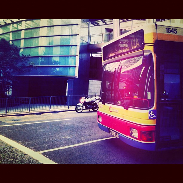 a yellow and red bus parked next to a building