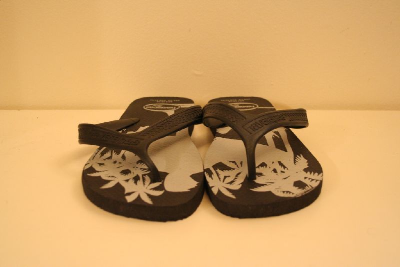 a pair of brown and white flip flops on top of a table