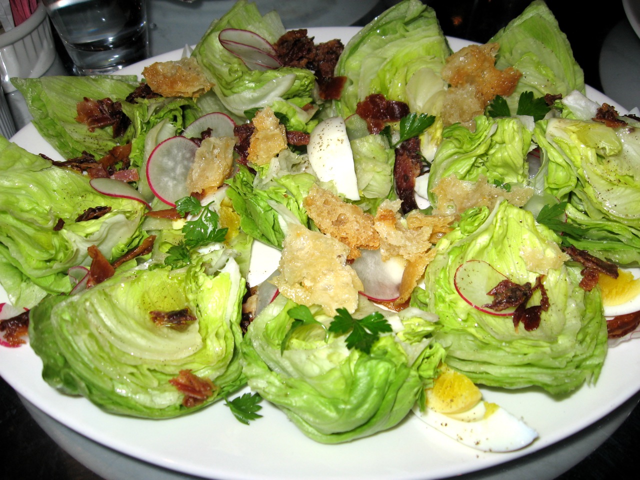 a large white plate topped with lettuce covered in toppings