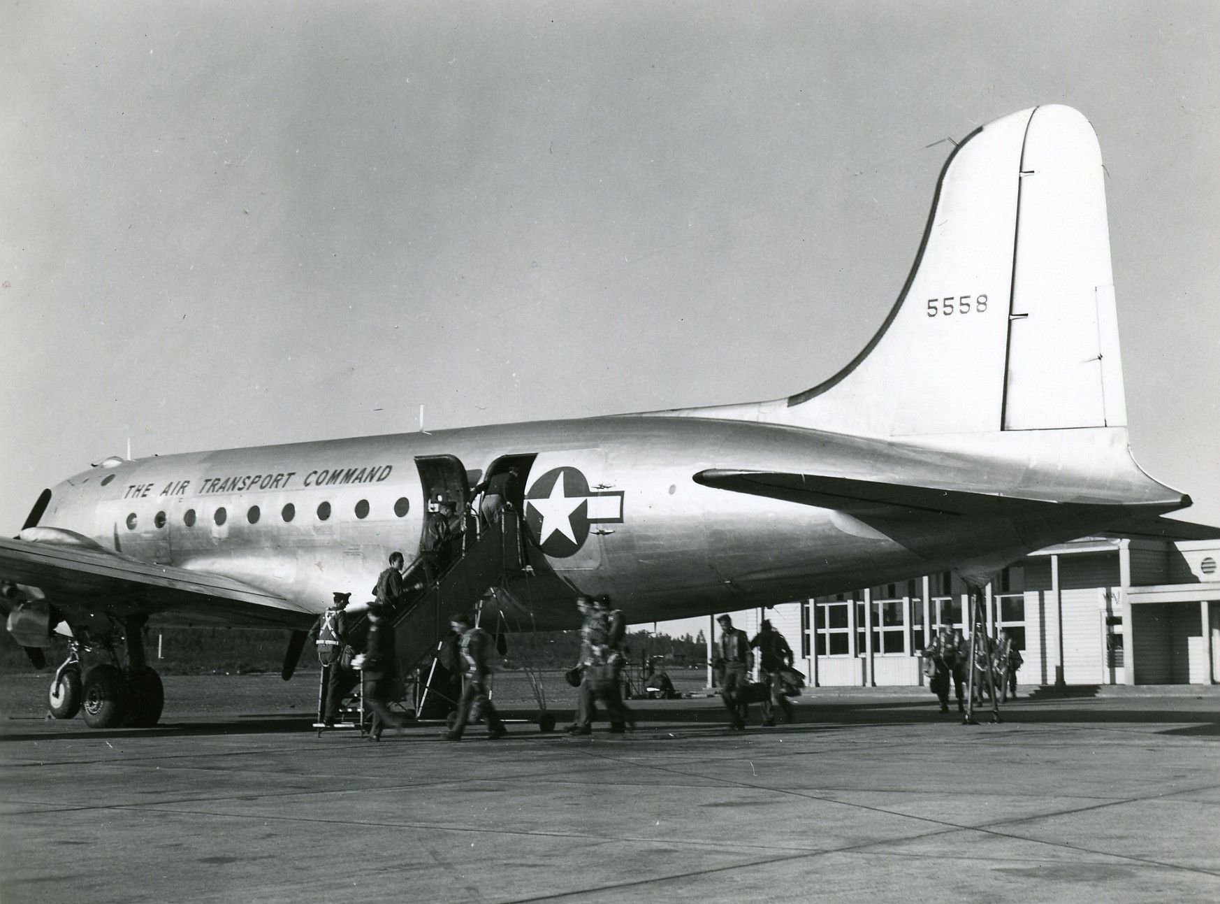 a large airplane parked in an airport next to some people