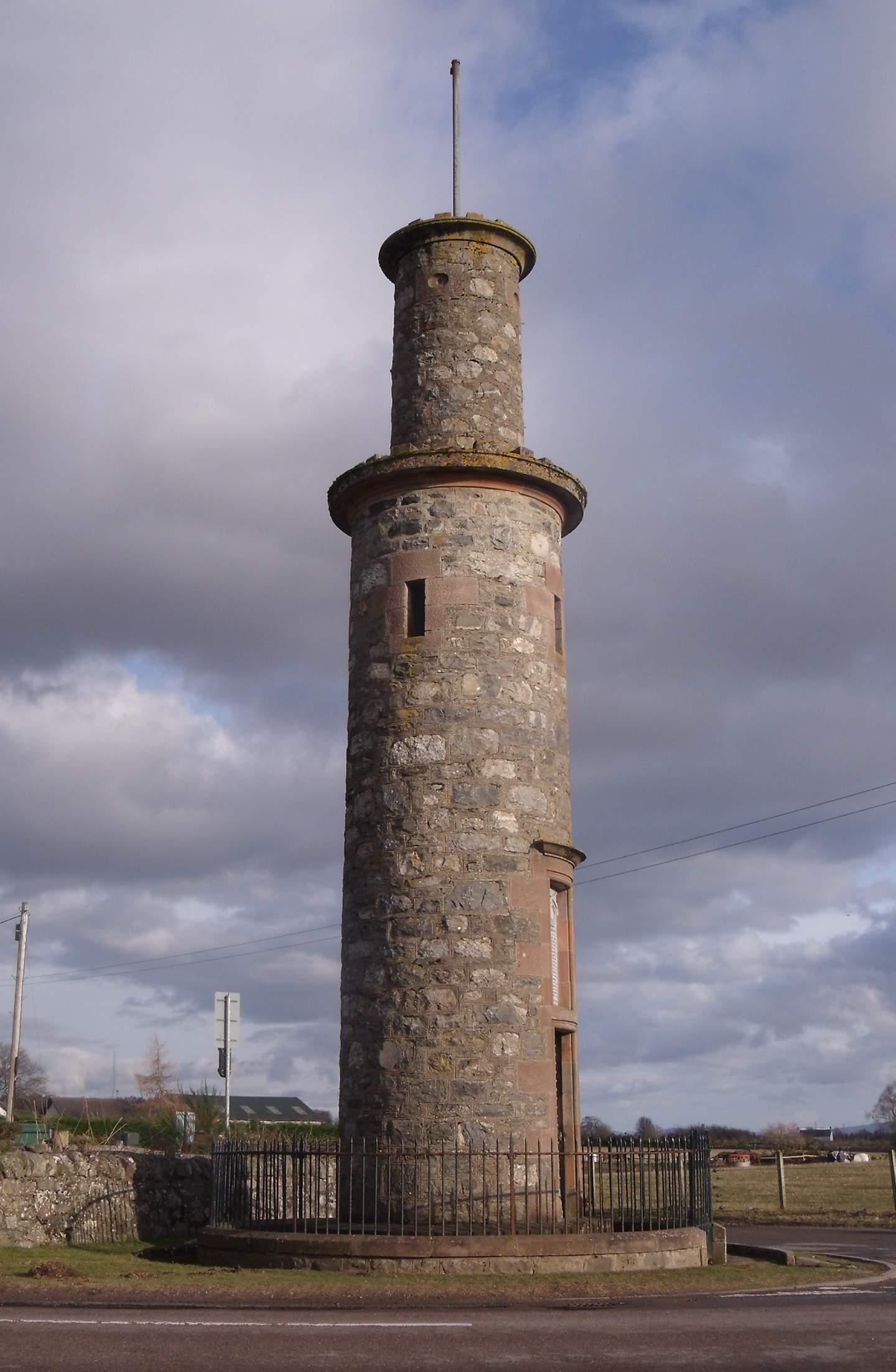 a large stone tower sits on a road