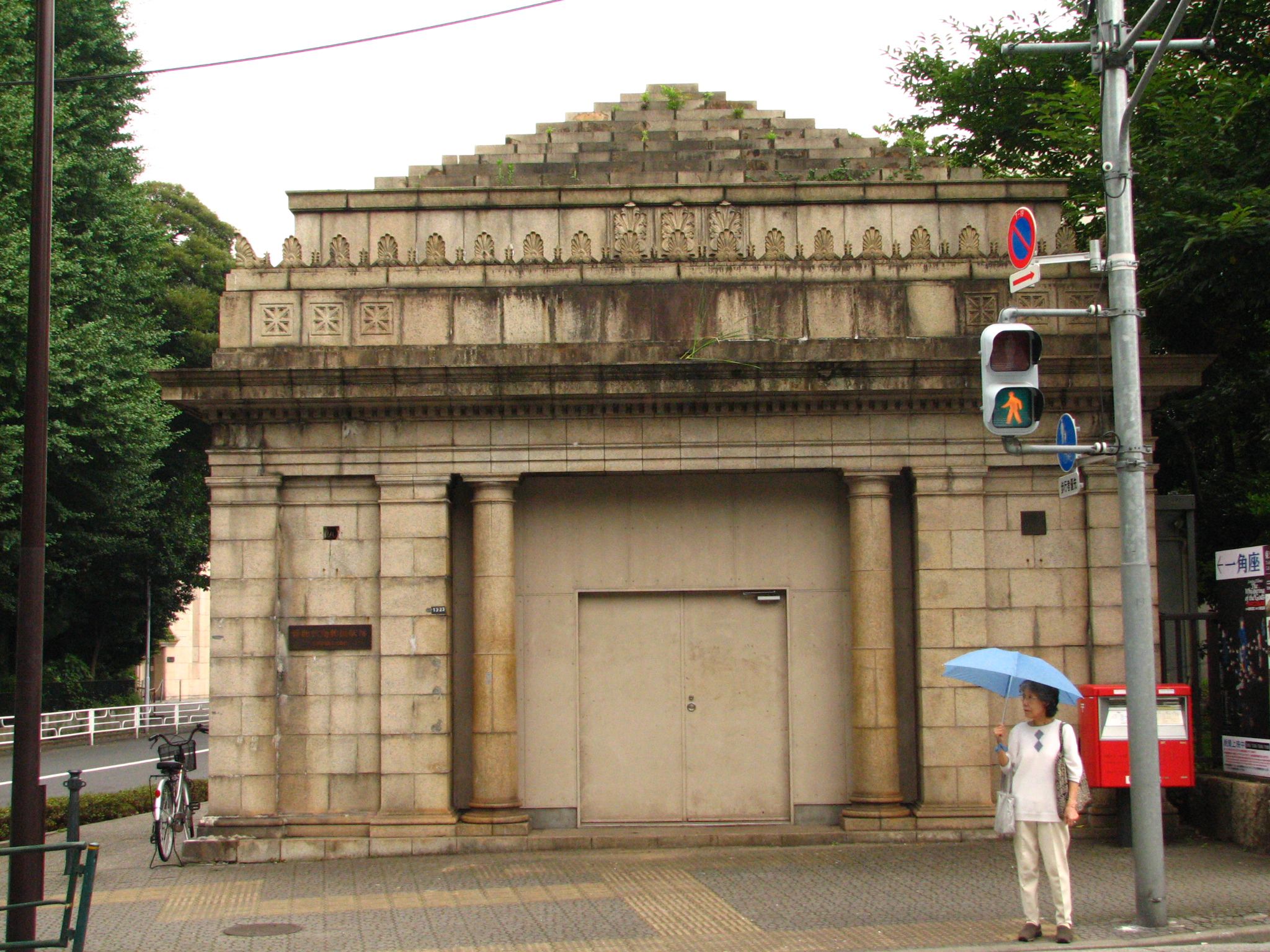 there is a person with an umbrella walking towards the stone temple