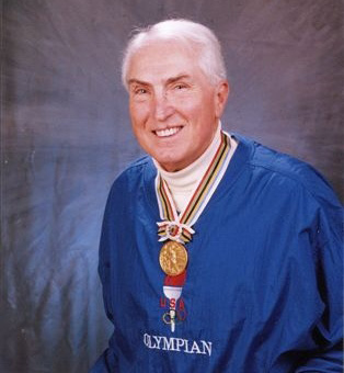 a man in blue jacket holding his gold medal