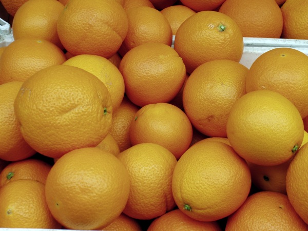 some oranges sitting together in crates for sale