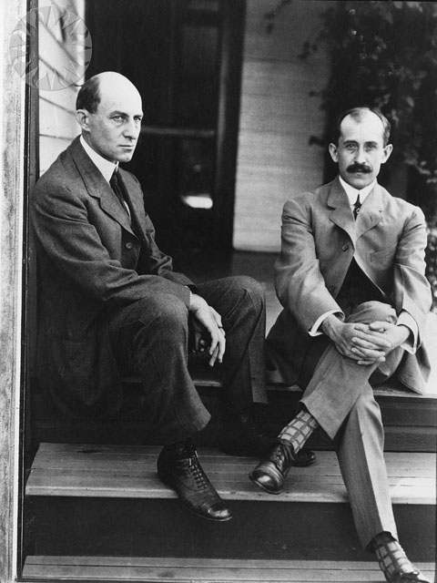 two men in suit and tie sitting on steps