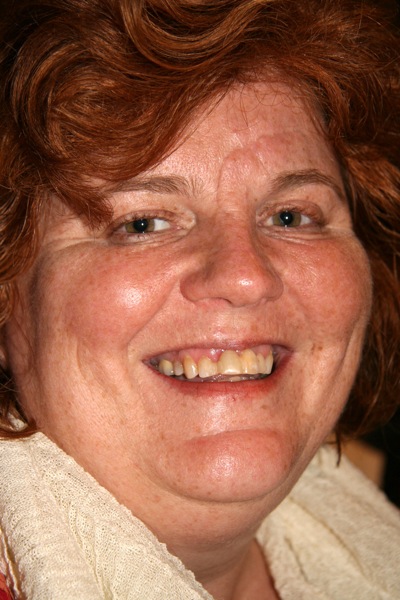 a women who is smiling and wearing a scarf