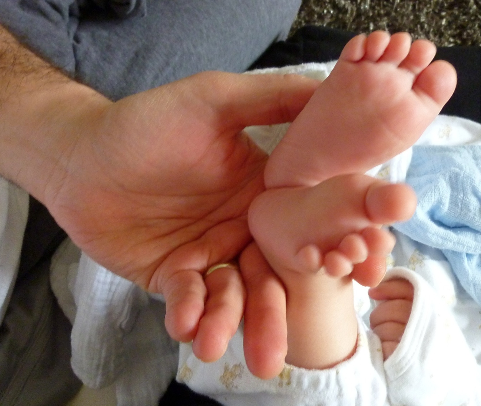 this is a man holding a baby's feet