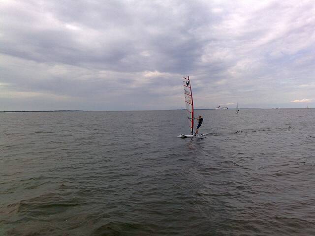 a sail boat with sails sailing on the ocean