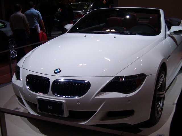 the white car is parked in a showroom