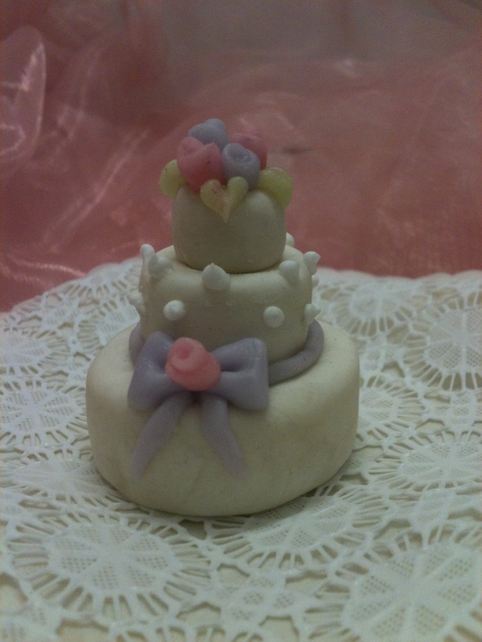 a three tier cake has bows and other decorations on it