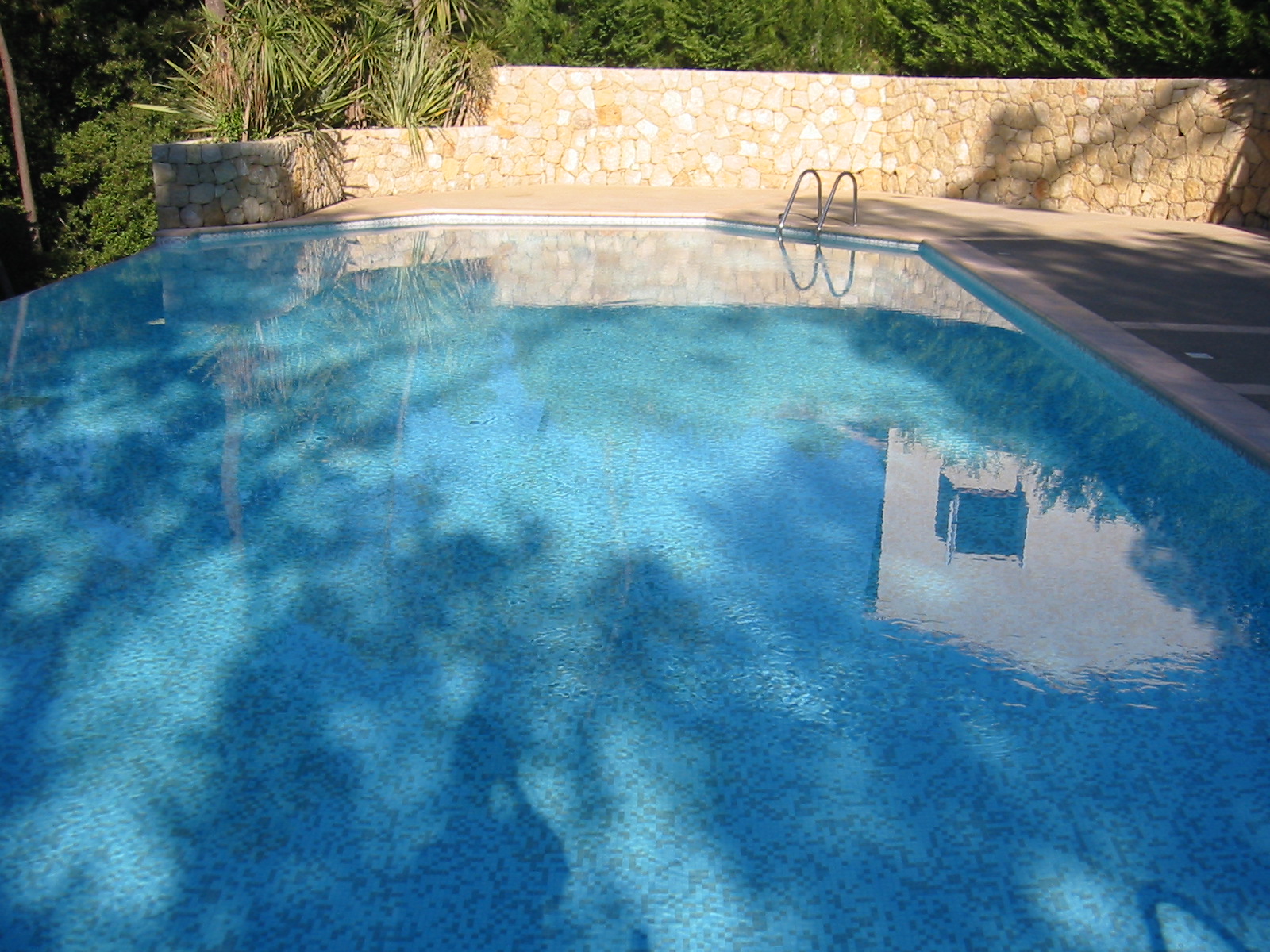 a blue swimming pool with a fenced in pool