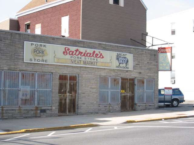 two story brick building with store front and cars parked outside