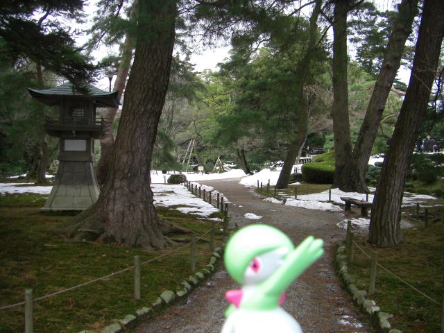 a small green and white toy is on a paved pathway