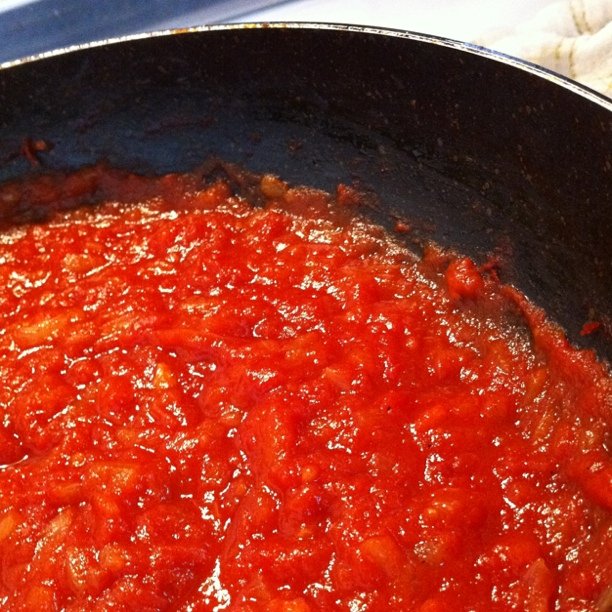 a pan filled with tomato sauce, sitting on a stove
