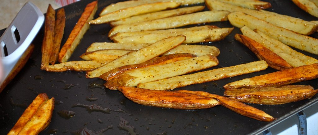 seasoned french fries sit on the side of a grill
