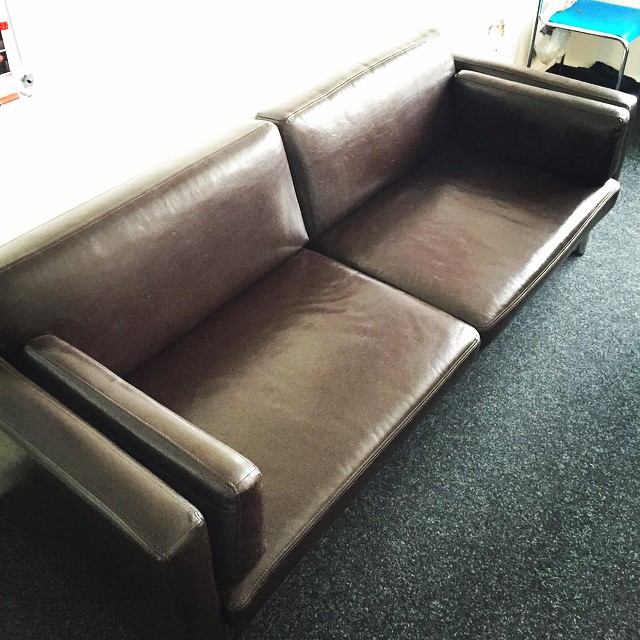 the couch is brown in color, with two arms extended