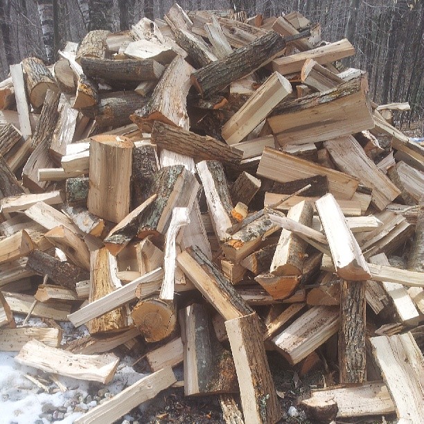 a pile of logs outside in the snow