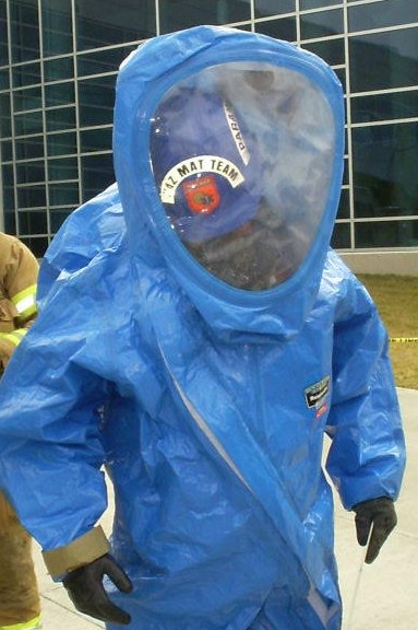 a person in a blue outfit standing next to a fireman