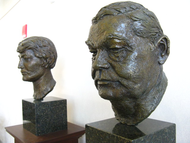 two bronze busts are facing opposite directions each other