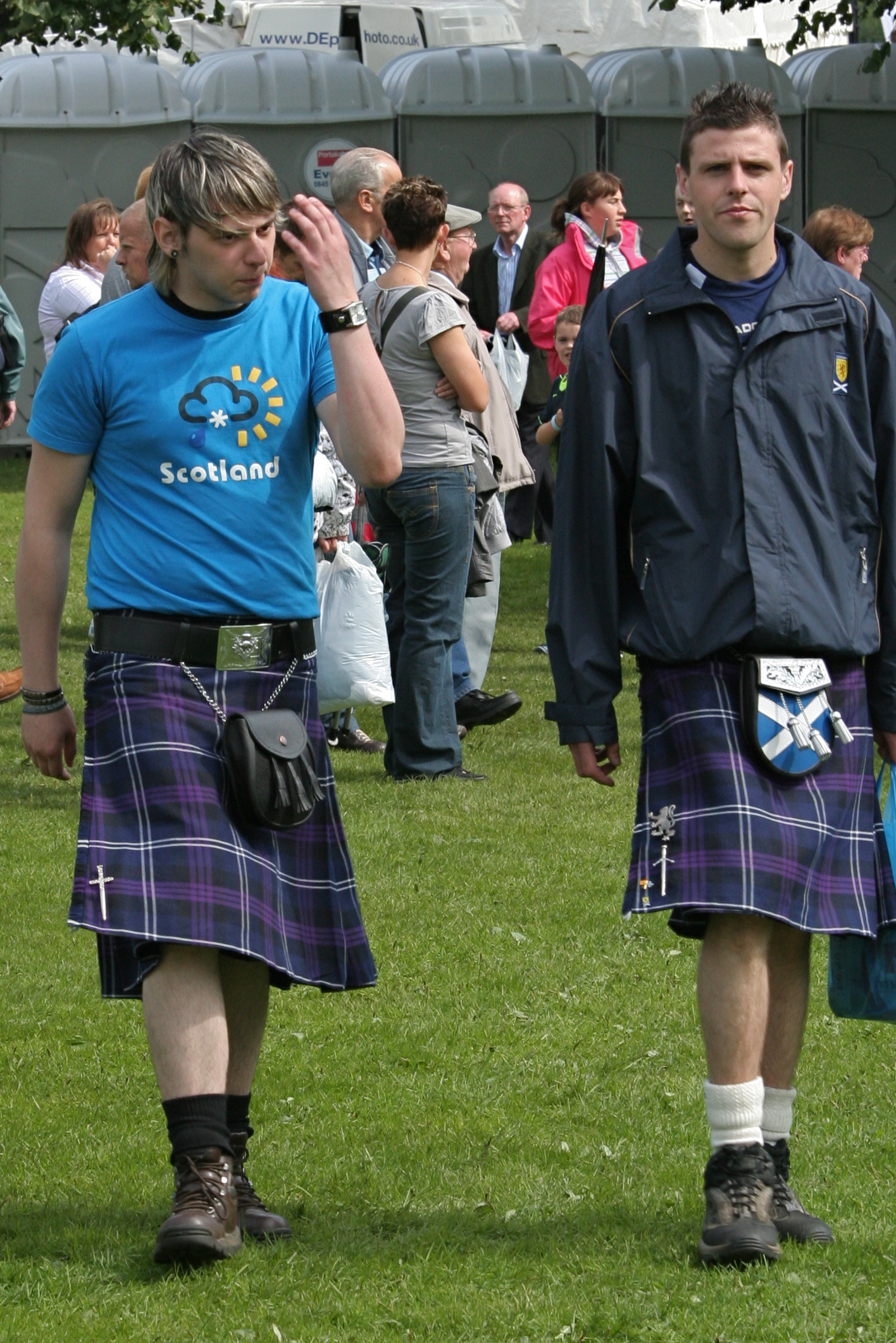 two men in kilts walking with their backs to each other