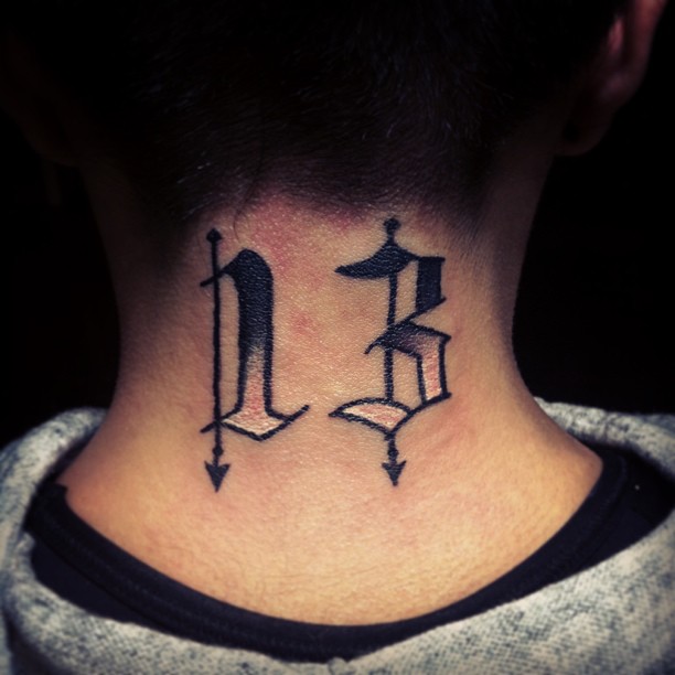 the neck tattoo has an arrow and sword designs