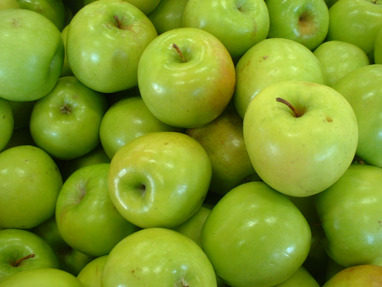 lots of green apples piled on top of each other