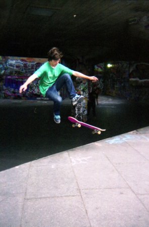 a young man riding a skateboard in a city