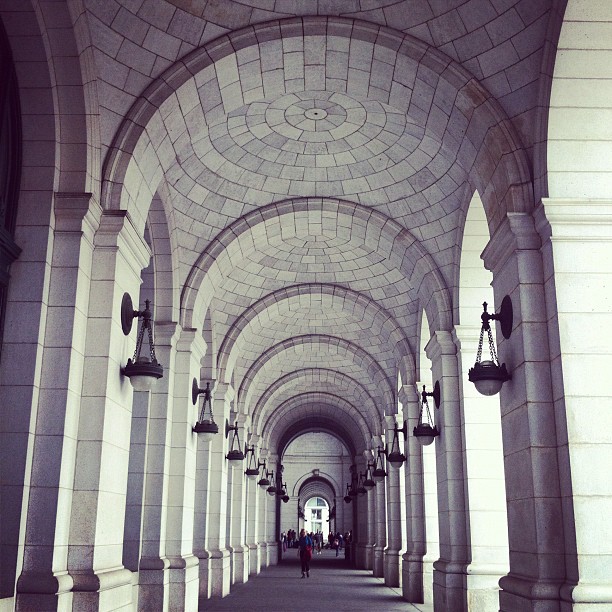arches are lined up along an empty hallway
