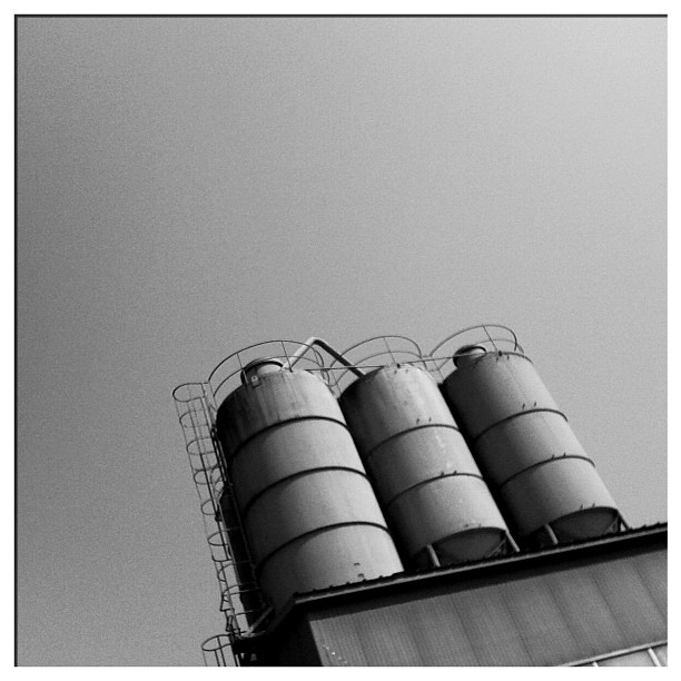an old grain silo is sitting under a partly cloudy sky