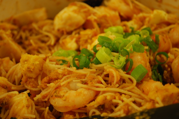 a dish of stir - fry noodles and shrimp with scallions
