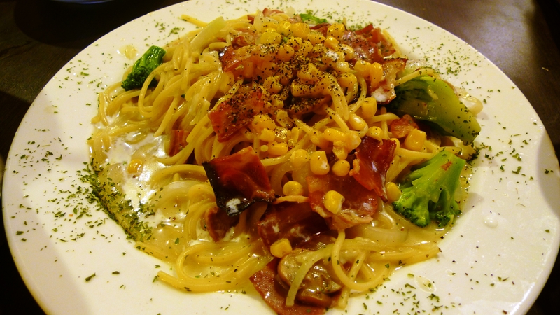 the pasta dish is topped with broccoli, corn, and tomatoes