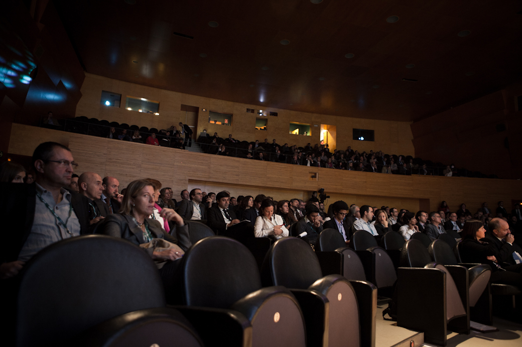 large crowd in a darkened room sitting in rows