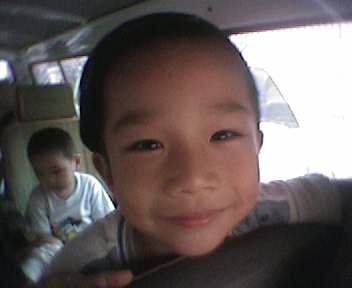 young child looking at camera in backseat of vehicle