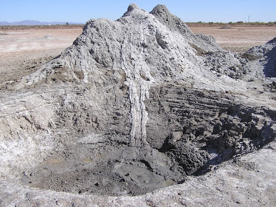 a large pile of rocks sitting on top of a desert field