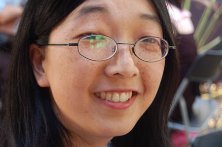 a woman with glasses is smiling at the camera