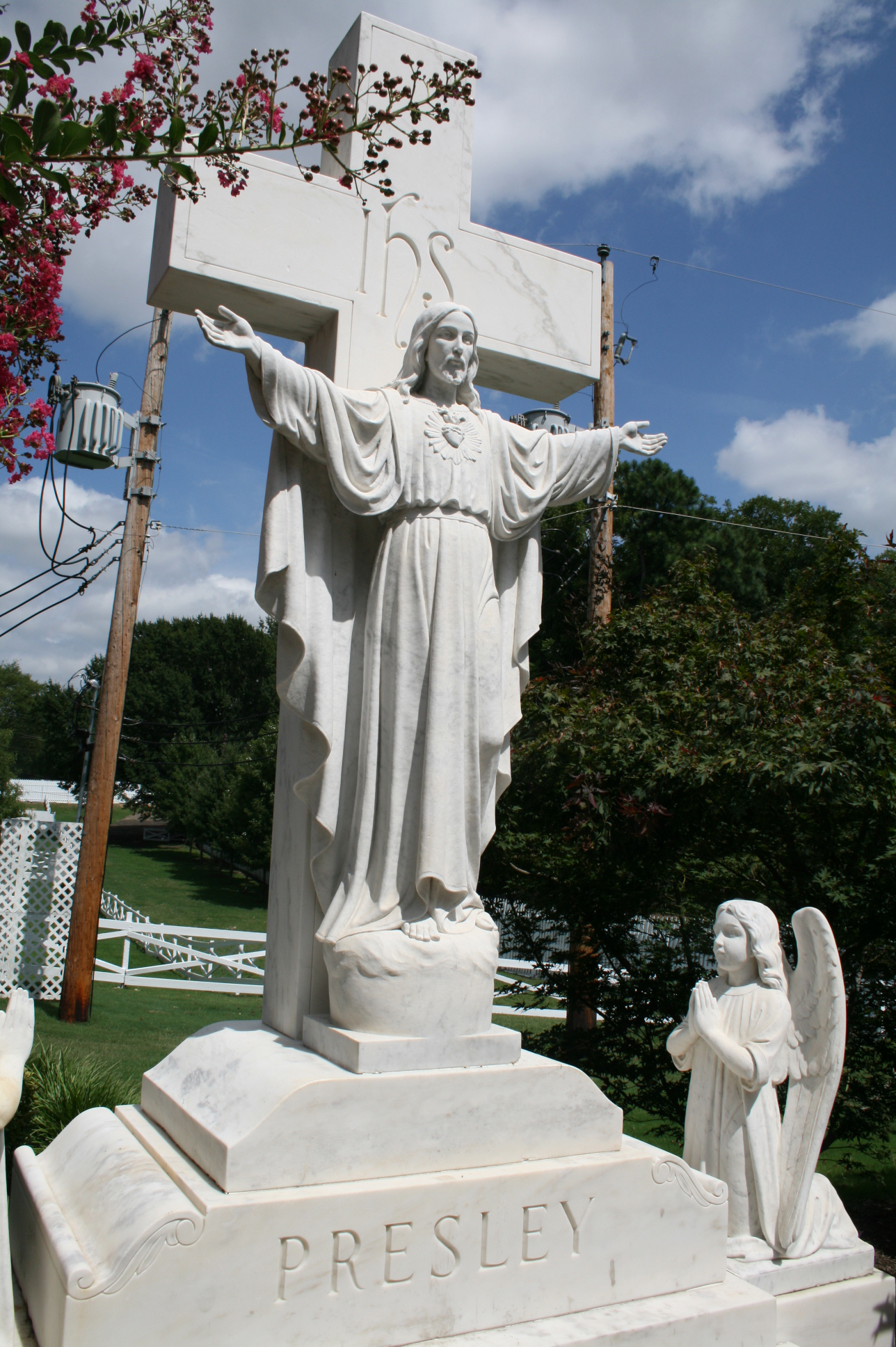 a statue of christ stands above an angel holding a cross