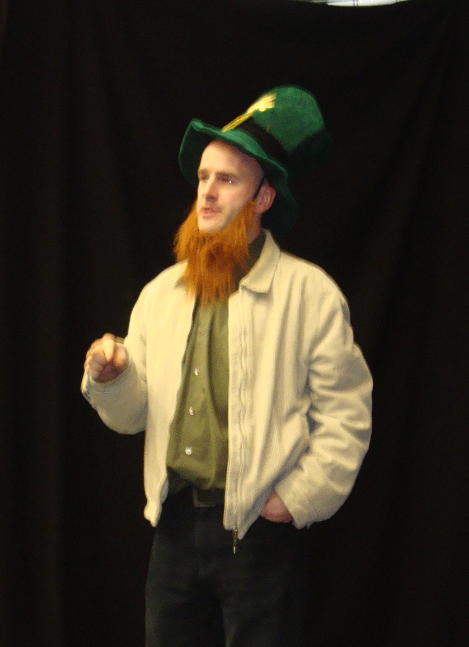 the bearded man wears a green hat and coat