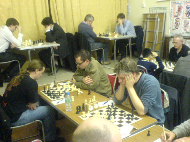 a game of chess surrounded by people playing it